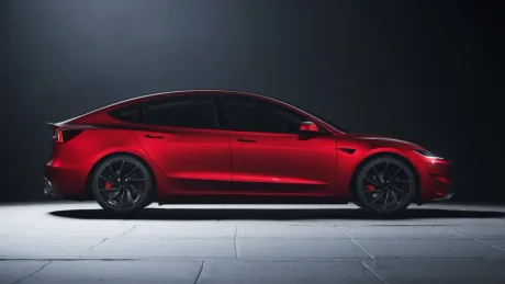 Model 3 Tesla, vopsea roșie, design elegant și sportiv, pe fundal întunecat.