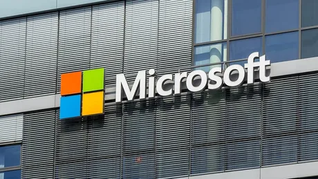 Logo Microsoft pe o clădire modernă, simbolizând parteneriatele tehnologice.