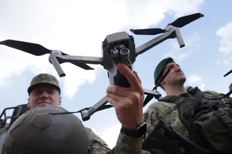 Dronă în mână, soldați pregătiți pentru misiune militară.