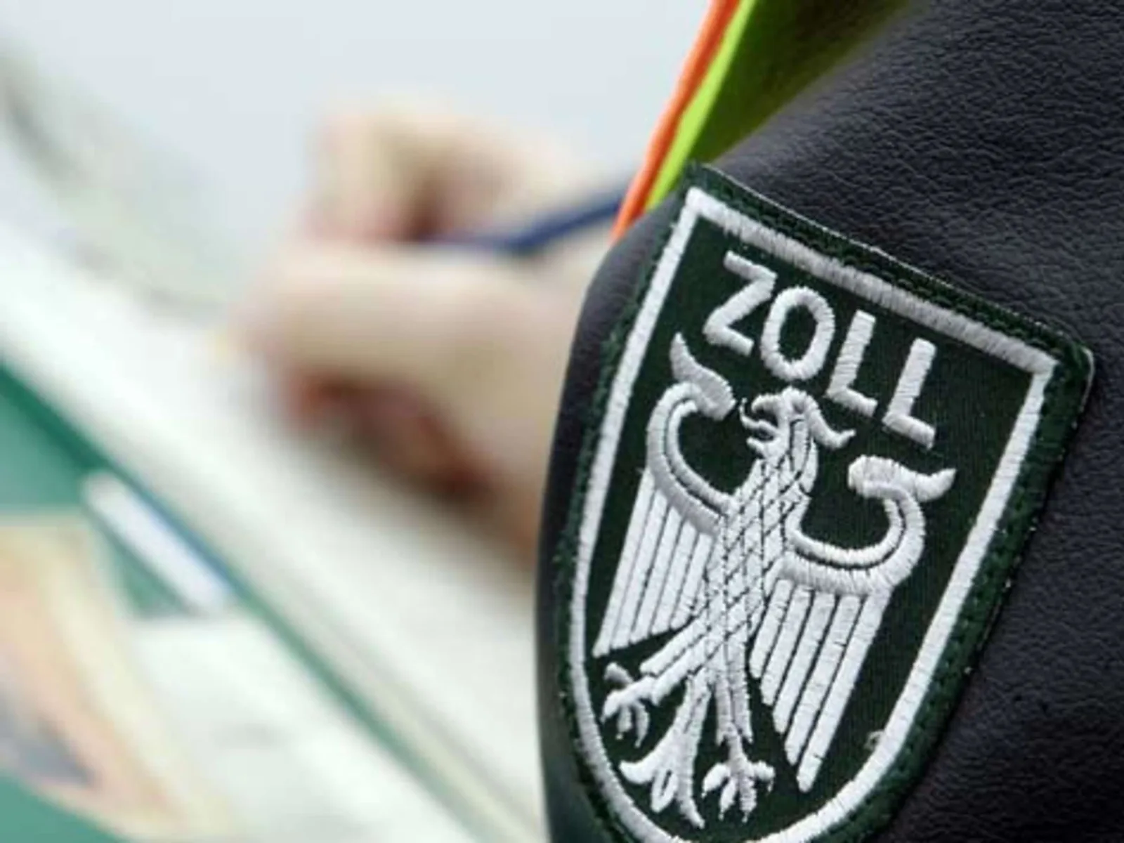 Insigna Zoll pe uniforma unui ofițer de vamă în timpul verificărilor.