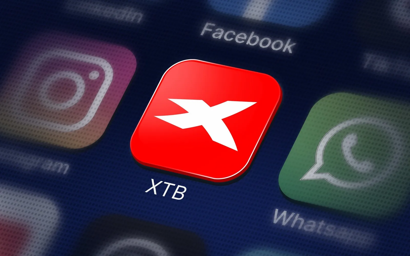 Logo XTB pe fundalul aplicațiilor de socializare populare.