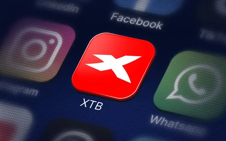 Logo XTB pe fundalul aplicațiilor de socializare populare.