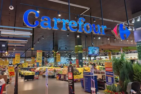 Interiorul unui magazin Carrefour cu produse proaspete și rafturi bine organizate.