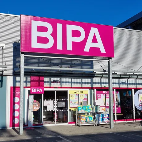 Magazin BIPA cu fațadă roz și produse expuse la intrare.