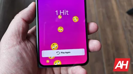 Ecran de telefon cu emoji pe fundal roz, interfață interactivă.