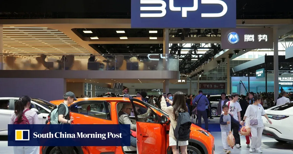 Standul BYD la un târg auto, cu vehicule electrice expuse și vizitatori curioși.