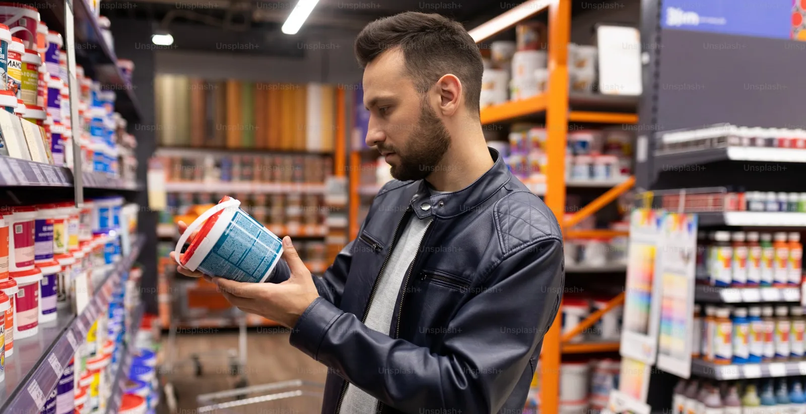 Un bărbat analizează un produs pe raft într-un magazin.