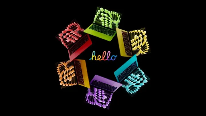 MacBook-uri colorate aranjate într-un cerc pe fundal negru