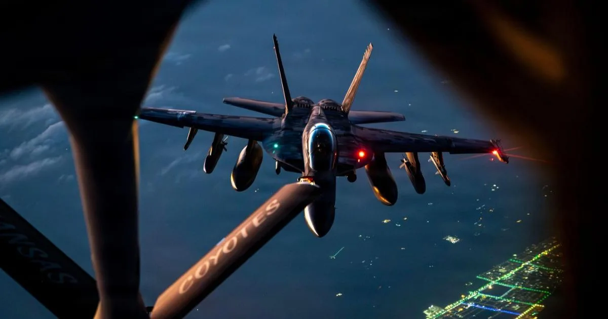 Avion militar în timpul realimentării aeriene deasupra unei zone urbane.