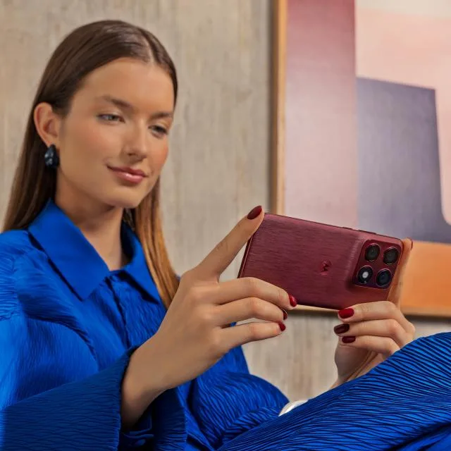 O persoană folosește un smartphone elegant, admirând designul său modern.