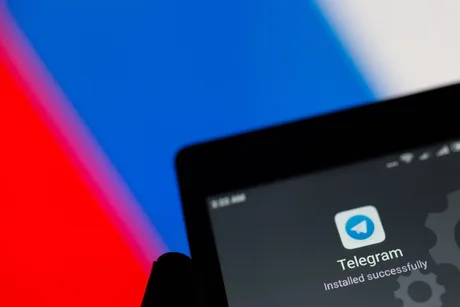 Logo-ul aplicației Telegram pe fundalul steagului rus.