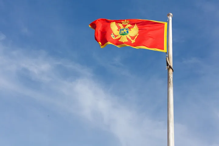 Steagul Muntenegrului fluturând sub un cer senin.