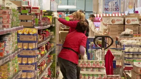 Persoane care fac cumpărături într-un magazin aglomerat.