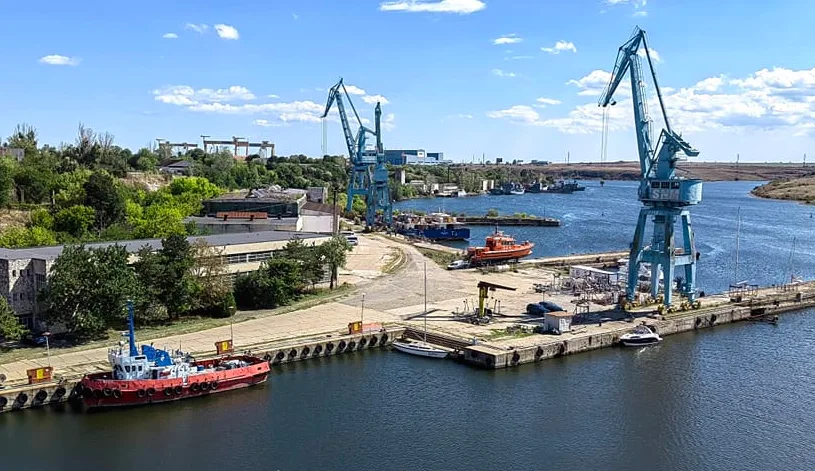 Vedere panoramică a șantierului naval Damen Mangalia pe malul apei.