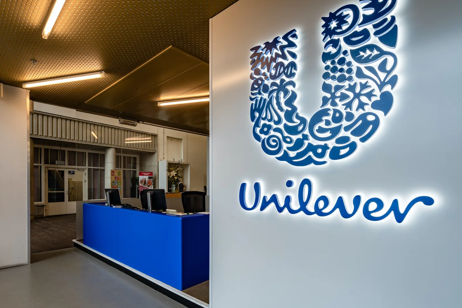 Logo Unilever într-un birou modern, cu iluminare caldă.