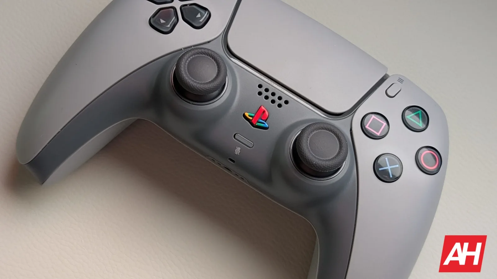 Controler PlayStation cu design modern și butoane colorate.