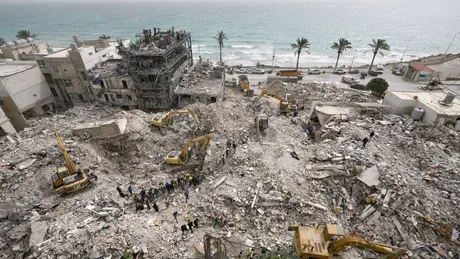 Peisaj urban distrus, cu excavatoare și muncitori în acțiune.