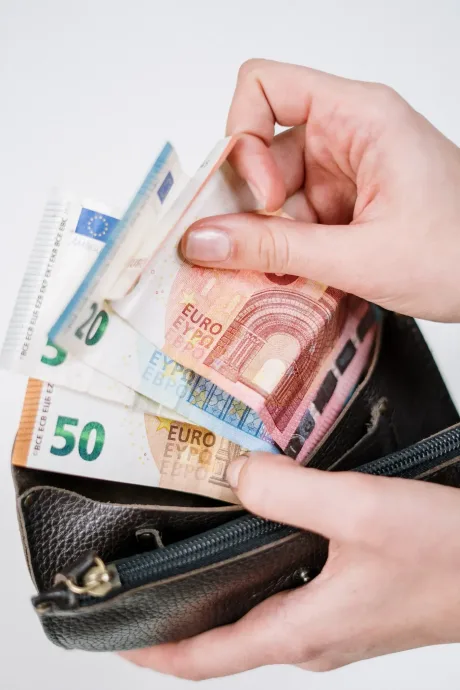 Bancnote de euro scoase dintr-un portofel negru.