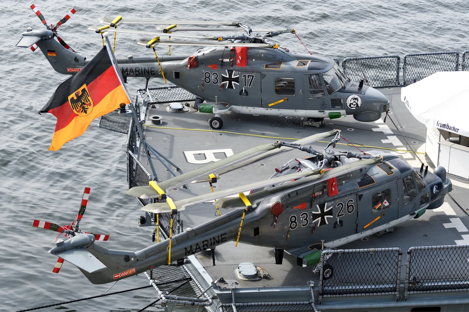 Două elicoptere militare pe un vas german, pregătite pentru operațiuni navale.