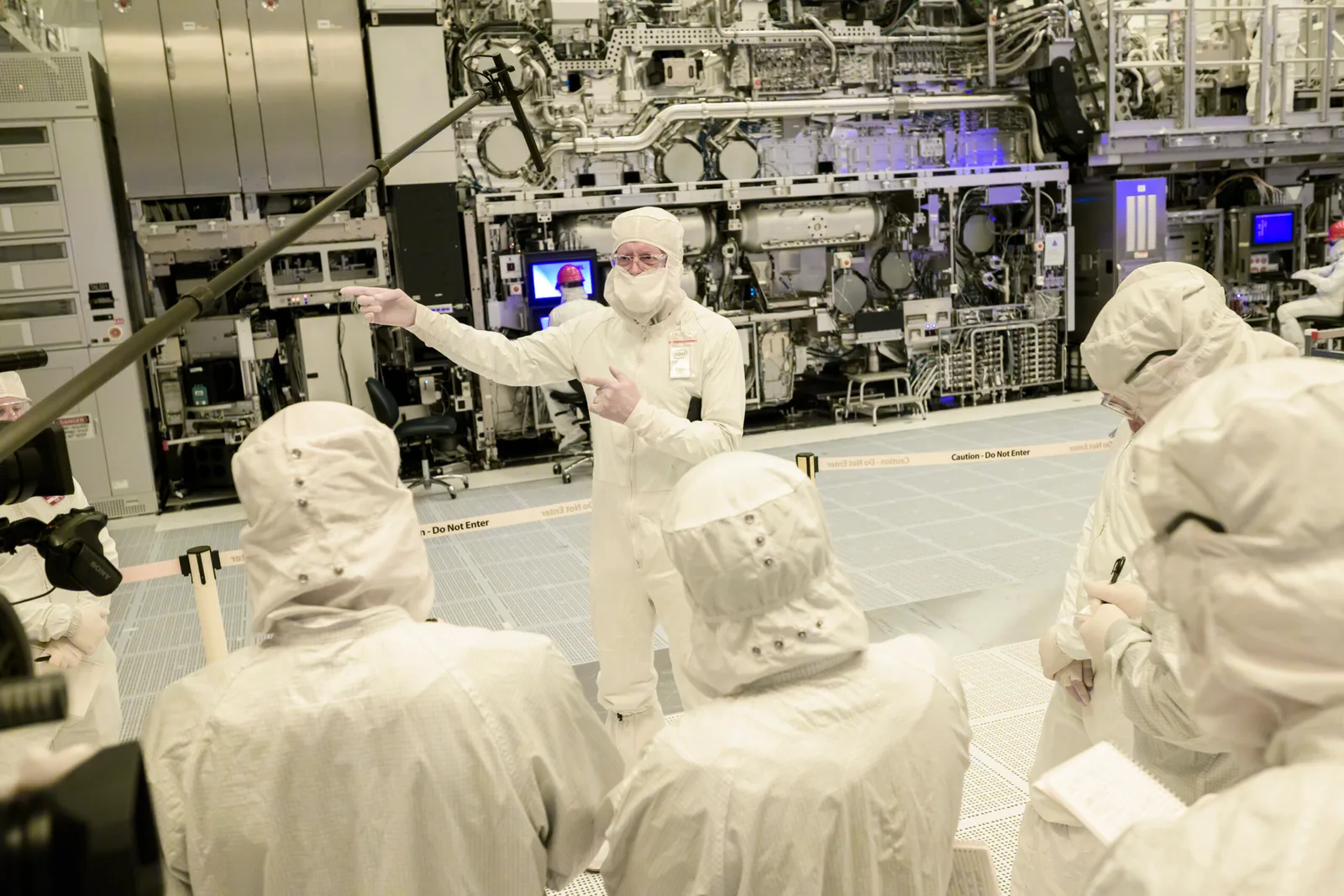 Specialiști discutând despre tehnologia High-NA EUV în fabrică.