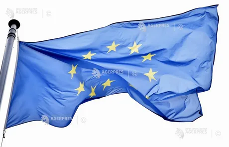 Steagul Uniunii Europene fluturând în vânt, simbol al unității și cooperării.