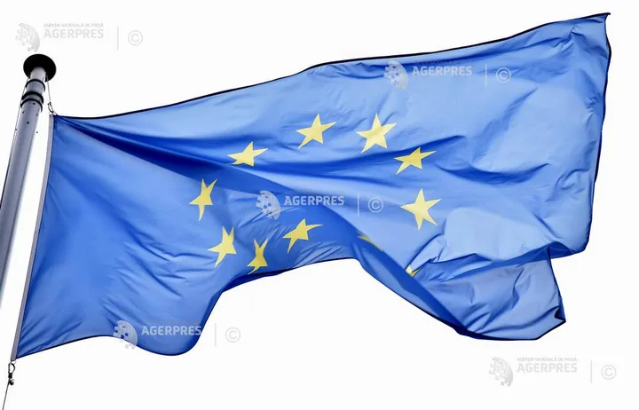 Steagul Uniunii Europene fluturând în vânt, simbol al unității și cooperării.