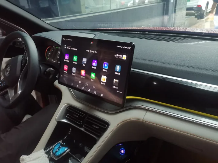 Interior modern de mașină cu ecran tactil mare și butoane fizice.