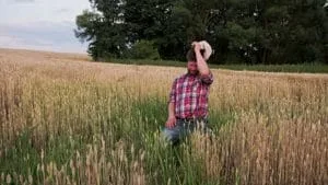 Fermier în câmp, afectat de întârzieri și taxe mari în agricultură.