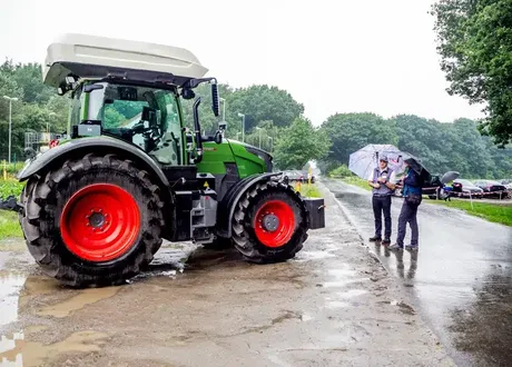 Tractor agricol modern pe drum, cu cercetători discutând despre tehnologia hidrogenului.