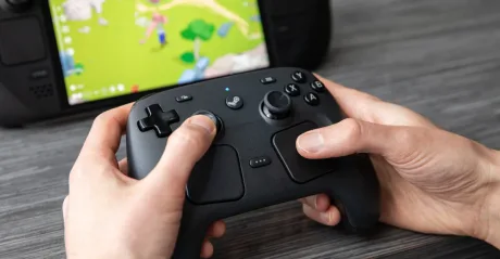 Utilizator jucându-se cu un controller Steam pe un dispozitiv.