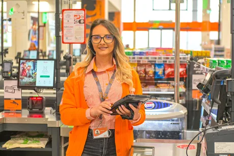 Angajată zâmbitoare la casă într-un supermarket ATAC din București.