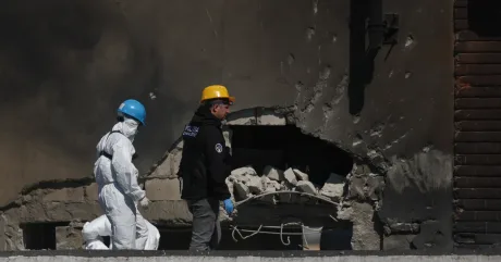Persoane în echipamente de protecție inspectează daunele provocate de o dronă în Galați.