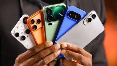 Cinci telefoane inteligente de diverse culori, ținute într-o mână.