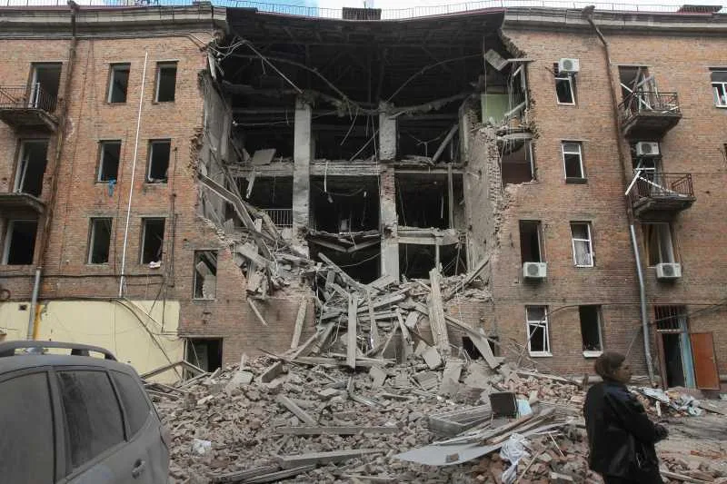 Clădire avariată grav în urma atacurilor cu drone, cu resturi de zidărie pe jos.