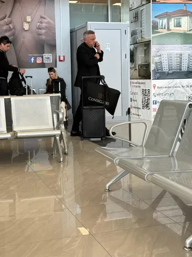 Ministrul Florin Barbu așteptând la aeroport cu o valiză de lux.