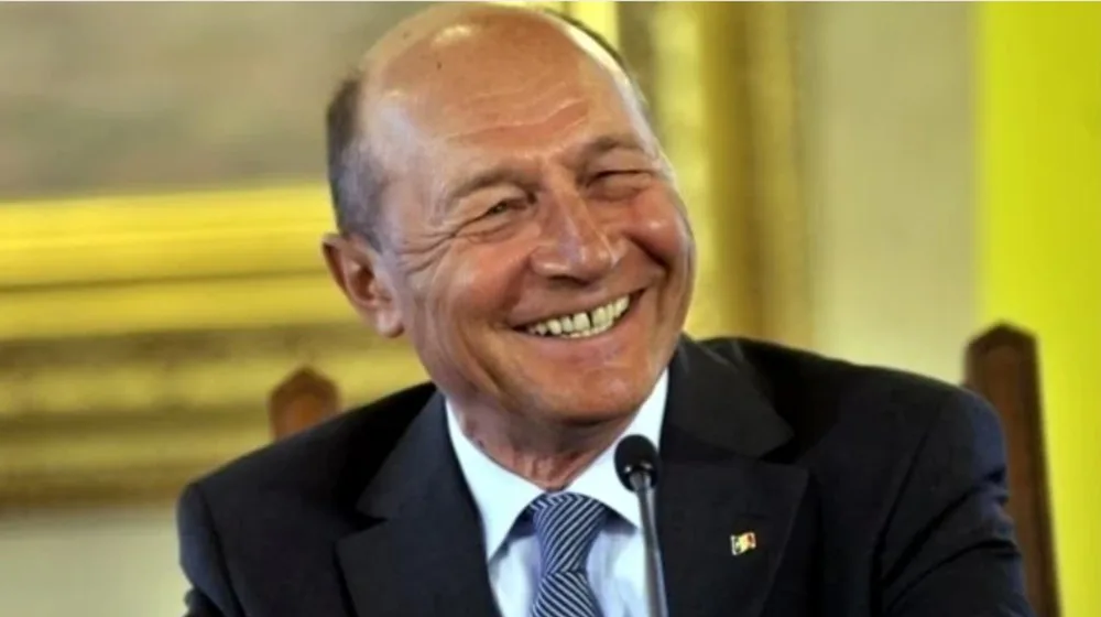Traian Băsescu zâmbește în timpul unei declarații publice.