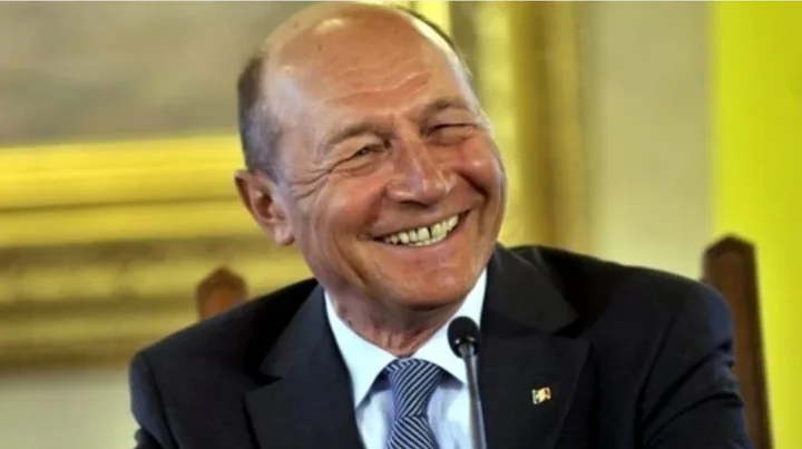 Traian Băsescu zâmbește în timpul unei declarații publice.