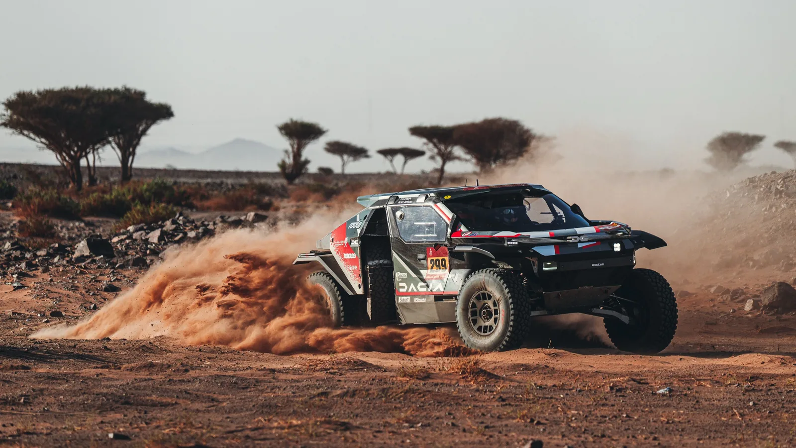 Dacia Sandrider în acțiune pe traseul Raliului Dakar 2026, în mijlocul peisajului arid.
