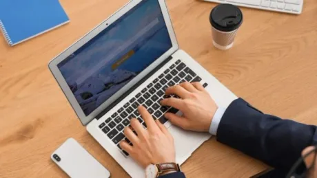 Un angajat lucrează la laptop, discutând despre concediu neefectuat.