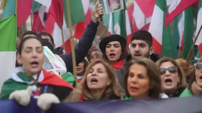Studenți protestând cu steaguri și pancarte în Teheran.