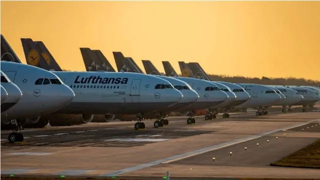 Avioane Lufthansa parcate pe pistă la apus, simbolizând greva piloților.