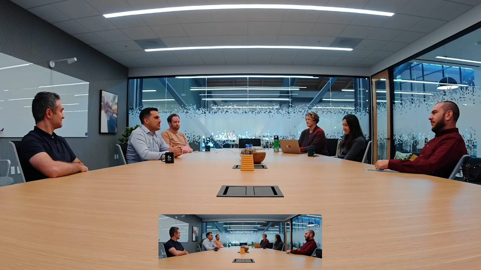 Discuție într-o sală de ședință modernă, cu participanți la videoconferință.