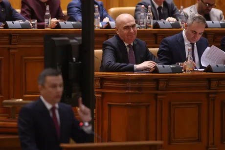 Parlamentarii discută despre moțiunea de cenzură în sala de ședințe.