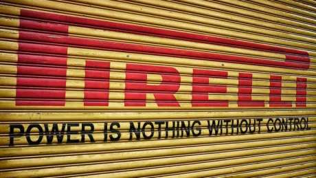 Logo Pirelli pe un panou de lemn galben.