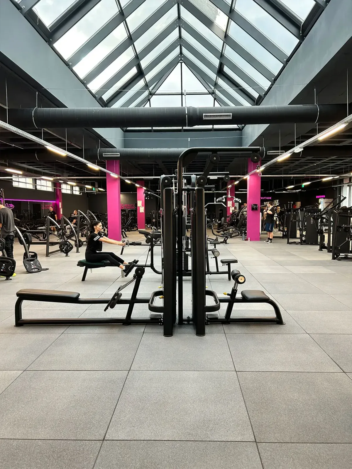 Sală de fitness modernă cu echipamente variate și iluminare naturală