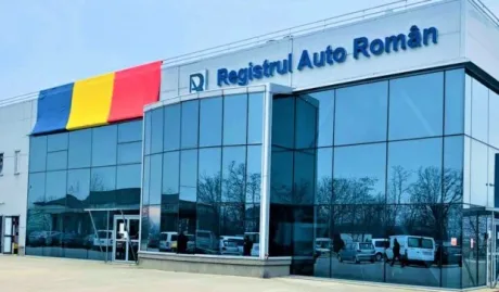 Clădirea Registrului Auto Român cu steagul României pe fațadă.