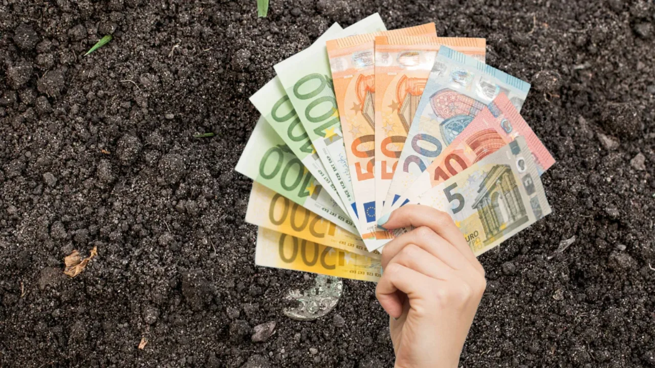 Bancnote de euro pe un fundal de pământ arabil, simbolizând plățile pentru fermieri.
