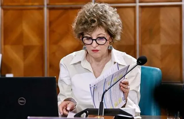 Oana Gheorghiu analizează documente despre listarea companiilor de stat la bursă.