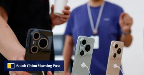 Utilizatori examinând smartphone-uri într-un magazin din China.