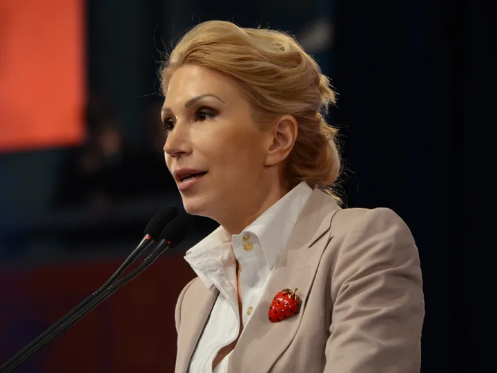 Raluca Turcan vorbește în fața jurnaliștilor, înconjurată de microfoane.